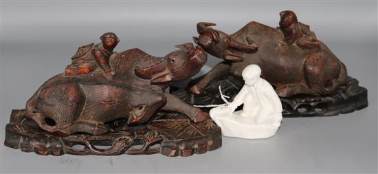A pair of Chinese hardwood buffalo and porcelain figure